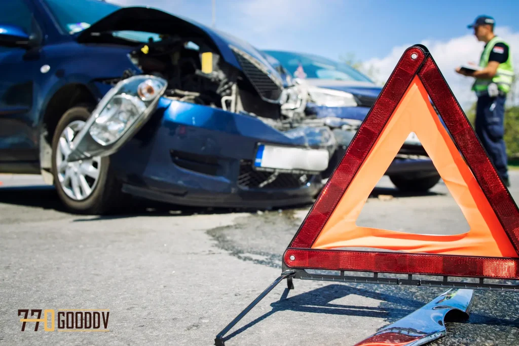 Car accident scene with visible damage, emergency warning triangle in the foreground, and an inspector evaluating the vehicles.